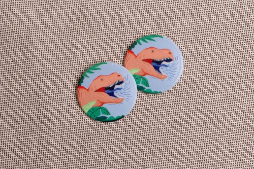 Badges showing an illustration of a roaring t-rex's head